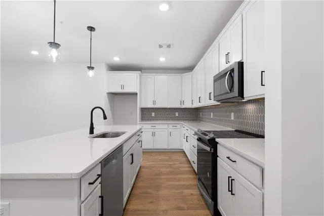 a kitchen with stainless steel appliances granite countertop a sink a stove and a refrigerator