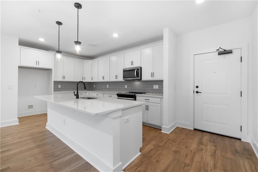 3321 Orwell Way, Unit 3301 Cumming, GA 30041 - Photo 12 of 43 a kitchen with kitchen island a sink stainless steel appliances and cabinets