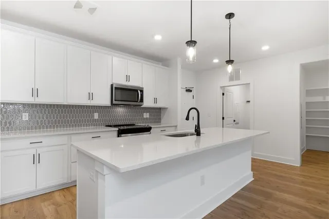 a kitchen with a sink a microwave a stove and refrigerator