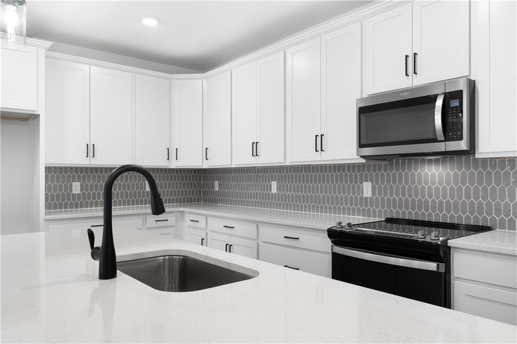 3321 Orwell Way, Unit 3301 Cumming, GA 30041 - Photo 10 of 43 a kitchen with granite countertop a sink and a stove top oven