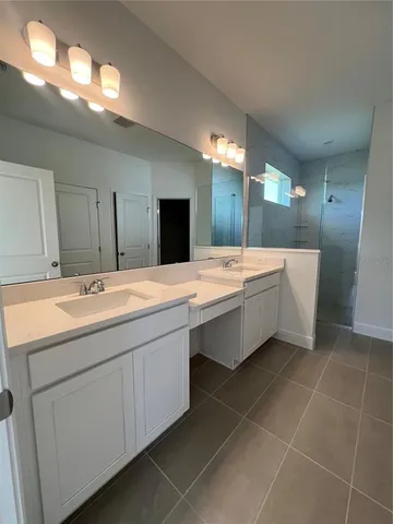 a bathroom with a double vanity sink mirror and bathtub