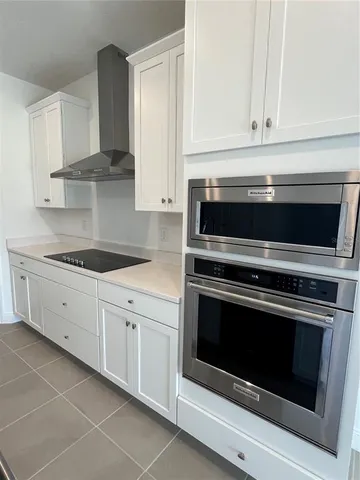 a kitchen with granite countertop white cabinets and stainless steel appliances
