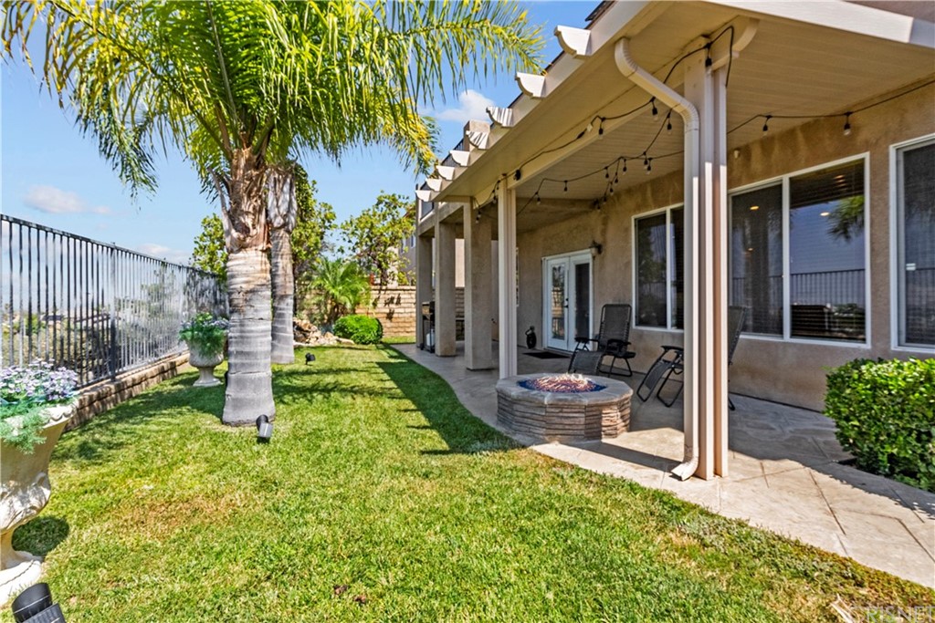 19654 Mathilde Lane Saugus, CA 91350 - Photo 22 of 38 a view of a patio with table and chairs potted plants and floor to ceiling window