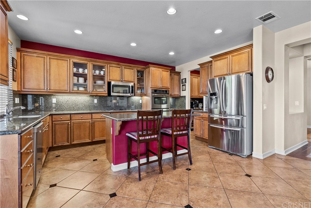 19654 Mathilde Lane Saugus, CA 91350 - Photo 9 of 38 a kitchen with stainless steel appliances granite countertop a stove refrigerator sink and cabinets