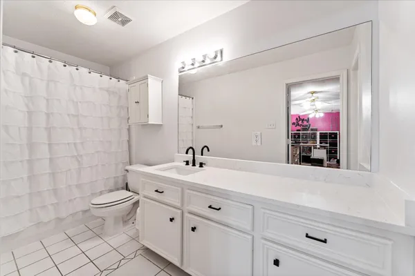 a bathroom with a double vanity sink mirror and toilet