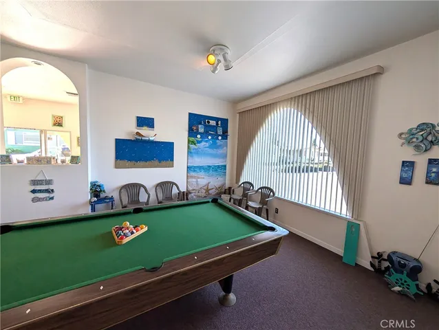 a room with pool table and windows