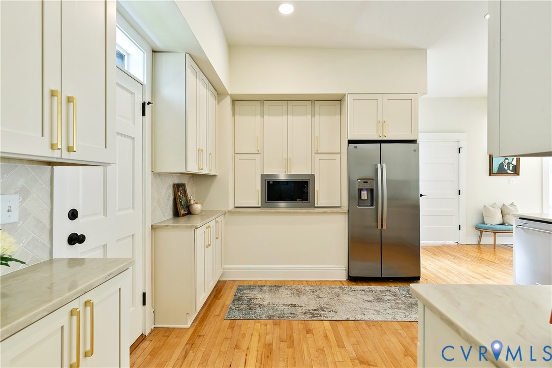 2402 Riverside Drive Richmond, VA 23225 - Photo 16 of 50 a kitchen with stainless steel appliances granite countertop a refrigerator a stove and white cabinets with wooden floor