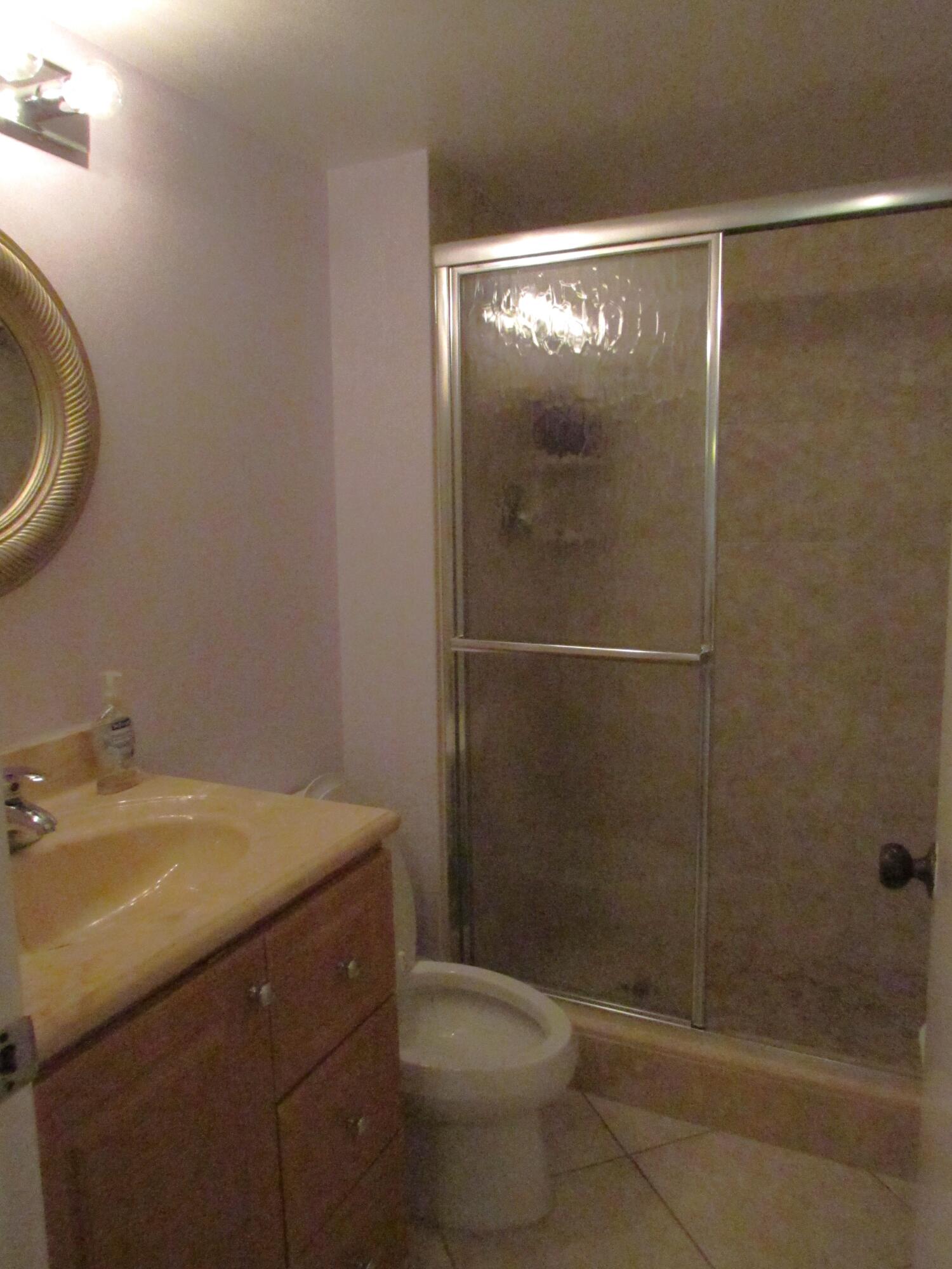 9872 Marina Boulevard, Unit 1438 Boca Raton, FL 33428 - Photo 11 of 18 a bathroom with a sink a toilet and shower
