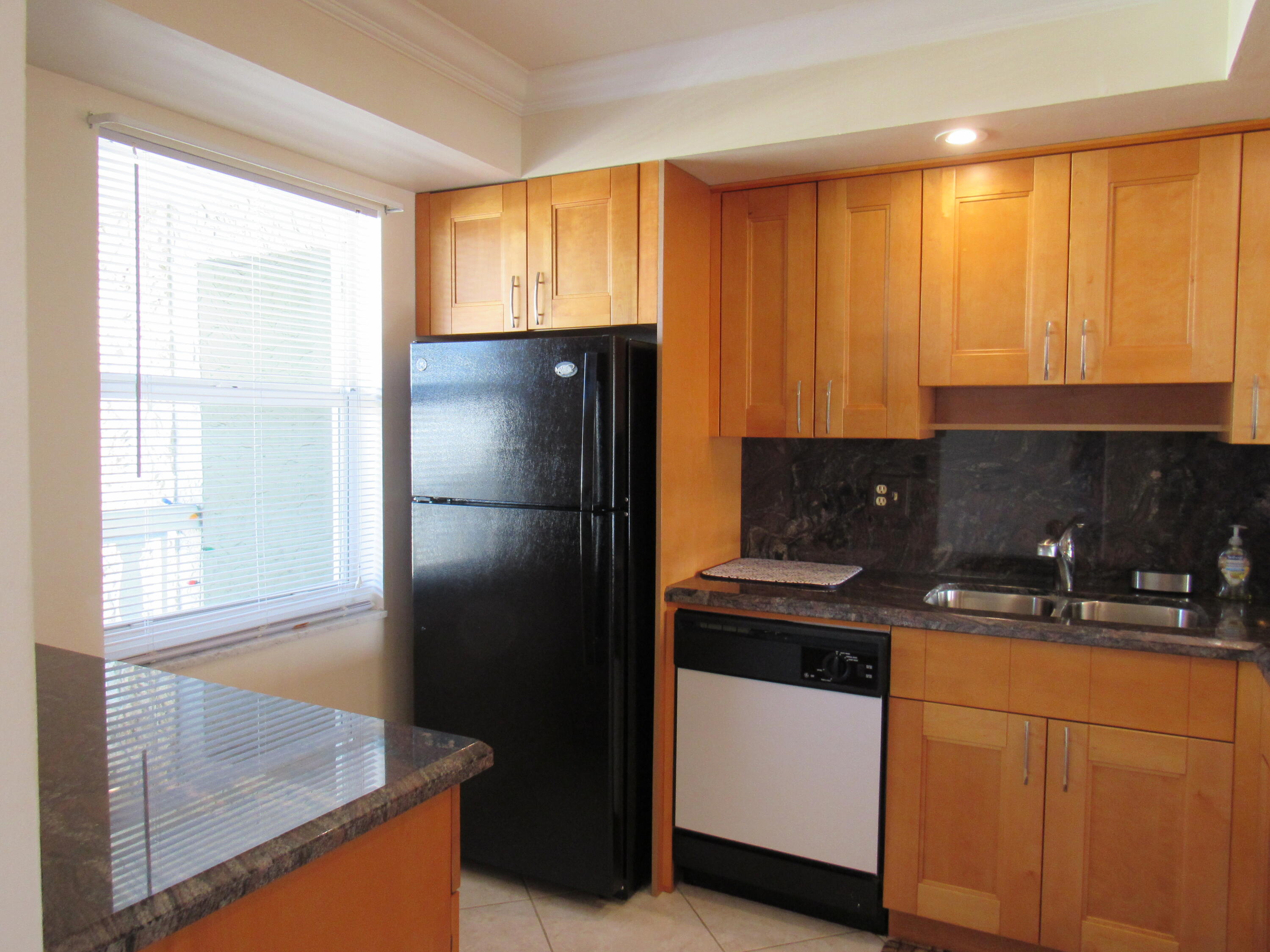 9872 Marina Boulevard, Unit 1438 Boca Raton, FL 33428 - Photo 4 of 18 a kitchen with a refrigerator and a sink