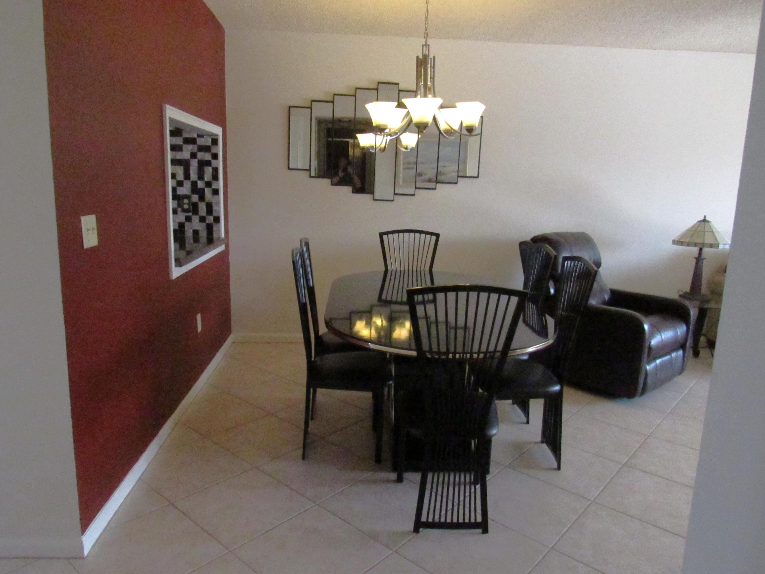 9872 Marina Boulevard, Unit 1438 Boca Raton, FL 33428 - Photo 6 of 18 a view of a dining room with furniture and chandelier