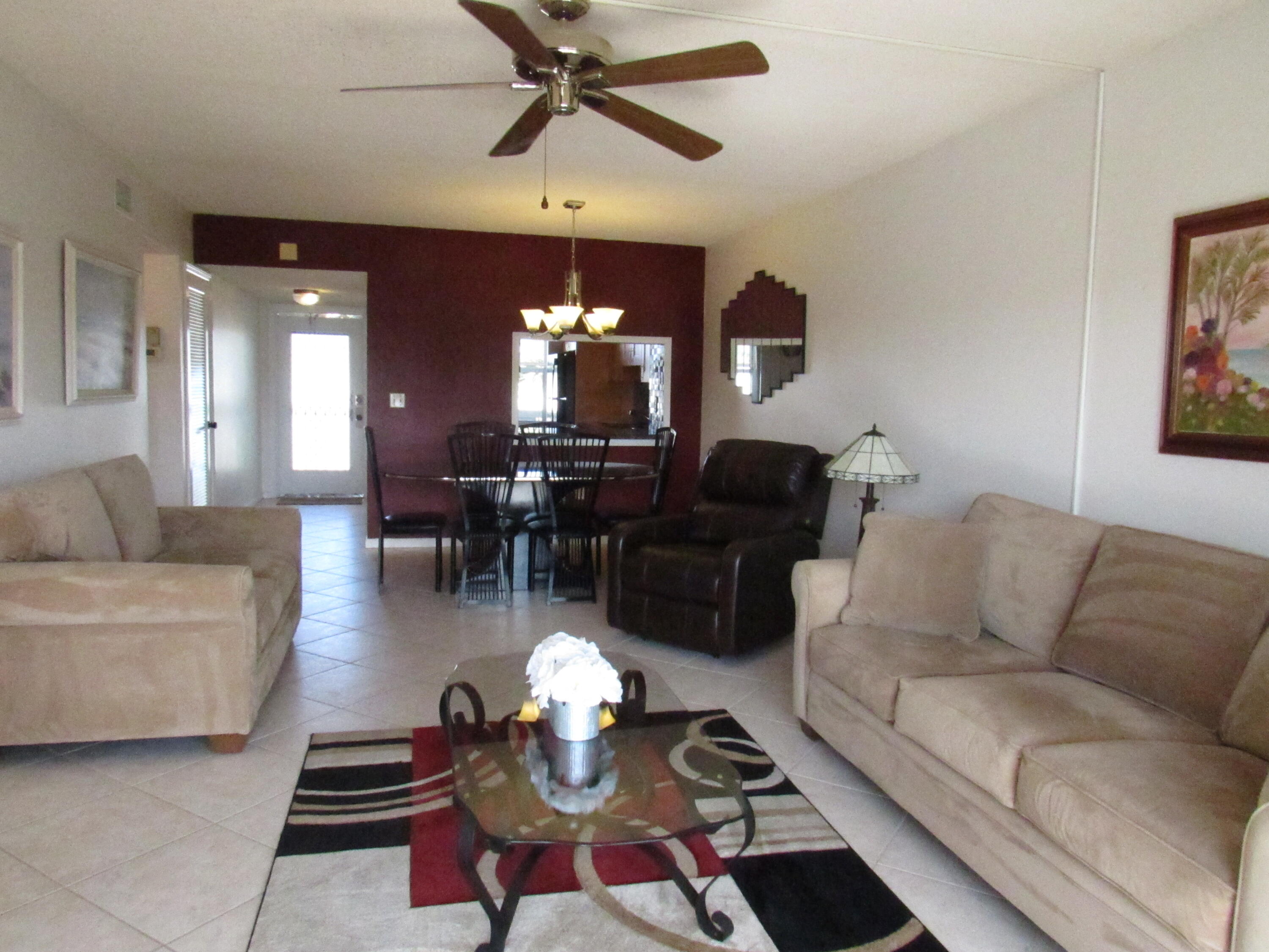9872 Marina Boulevard, Unit 1438 Boca Raton, FL 33428 - Photo 9 of 18 a living room with furniture and a chandelier
