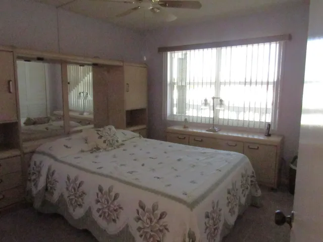 a bedroom with a bed and a dresser next to a window