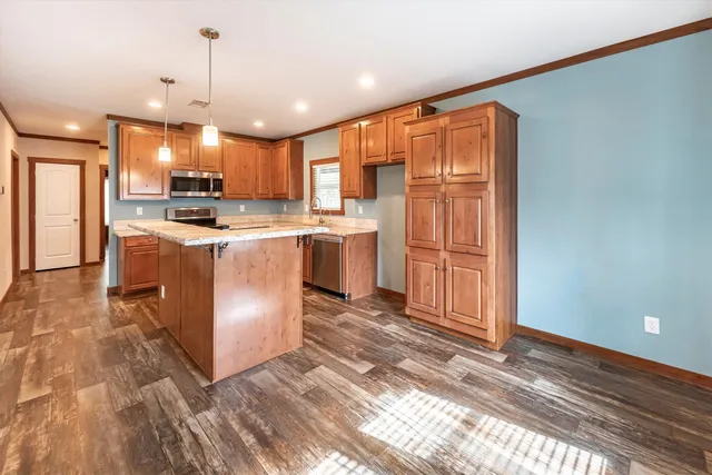 a kitchen with a sink a counter top space stainless steel appliances and cabinets