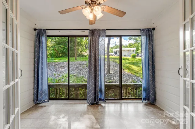 a view of a room with large windows and wooden floor