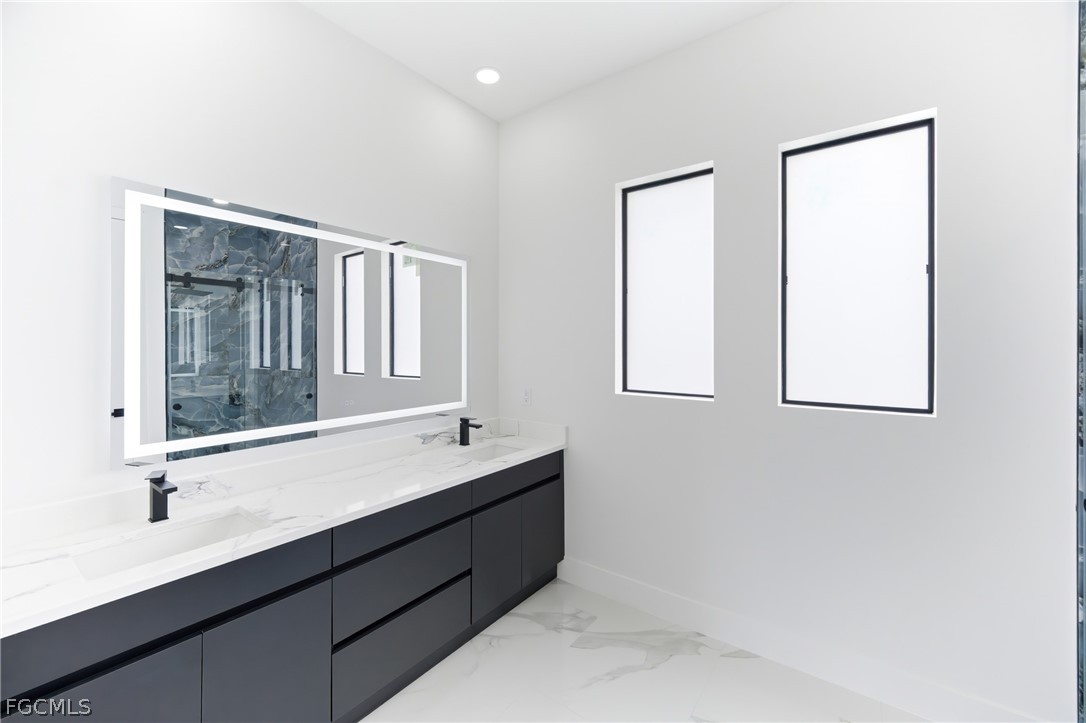 1013 Anson Avenue Lehigh Acres, FL 33971 - Photo 19 of 33 a bathroom with a double vanity sink and a mirror