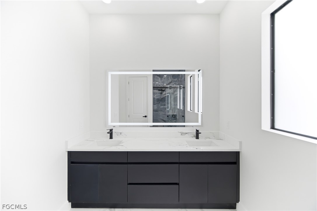 1013 Anson Avenue Lehigh Acres, FL 33971 - Photo 20 of 33 a bathroom with a sink and a mirror