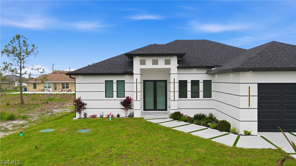 1013 Anson Avenue Lehigh Acres, FL 33971 - Photo 2 of 33 a front view of a house with a yard