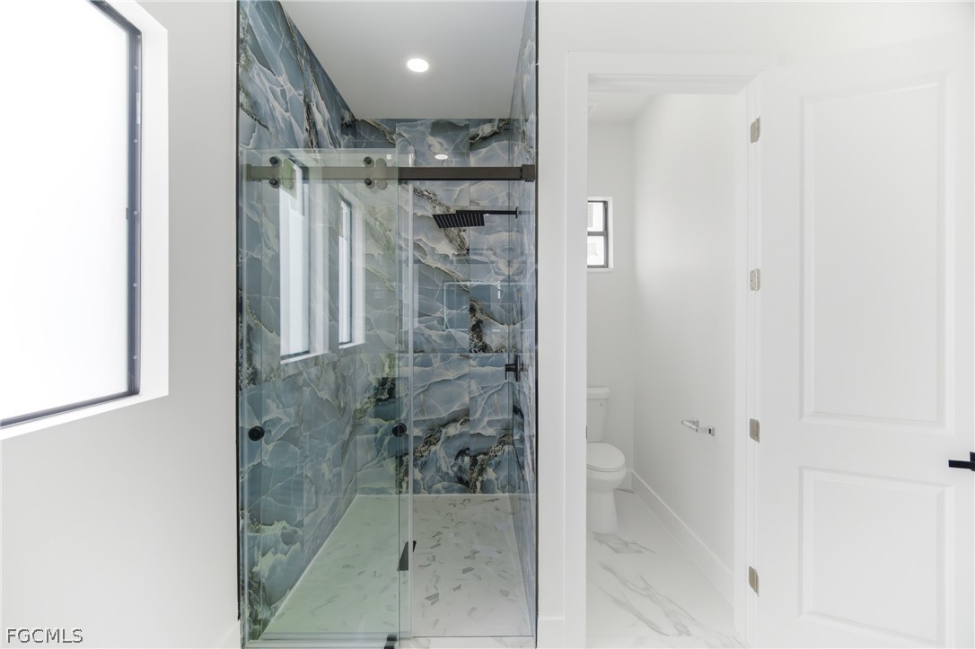 1013 Anson Avenue Lehigh Acres, FL 33971 - Photo 21 of 33 a bathroom with a glass shower door