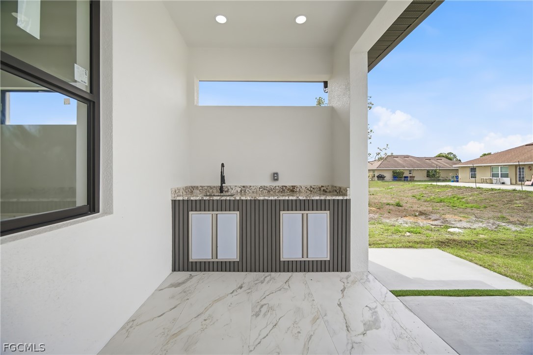 1013 Anson Avenue Lehigh Acres, FL 33971 - Photo 24 of 33 a view of a living room with a floor to ceiling window and a kitchen area