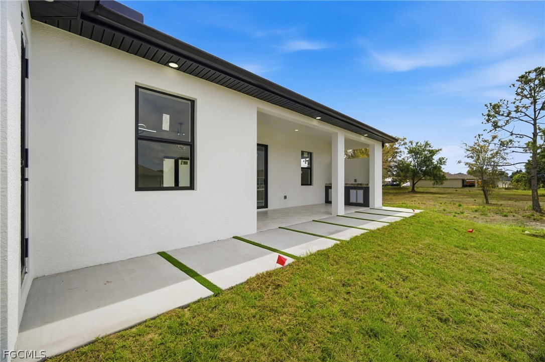 1013 Anson Avenue Lehigh Acres, FL 33971 - Photo 26 of 33 a view of an house with backyard porch and garden