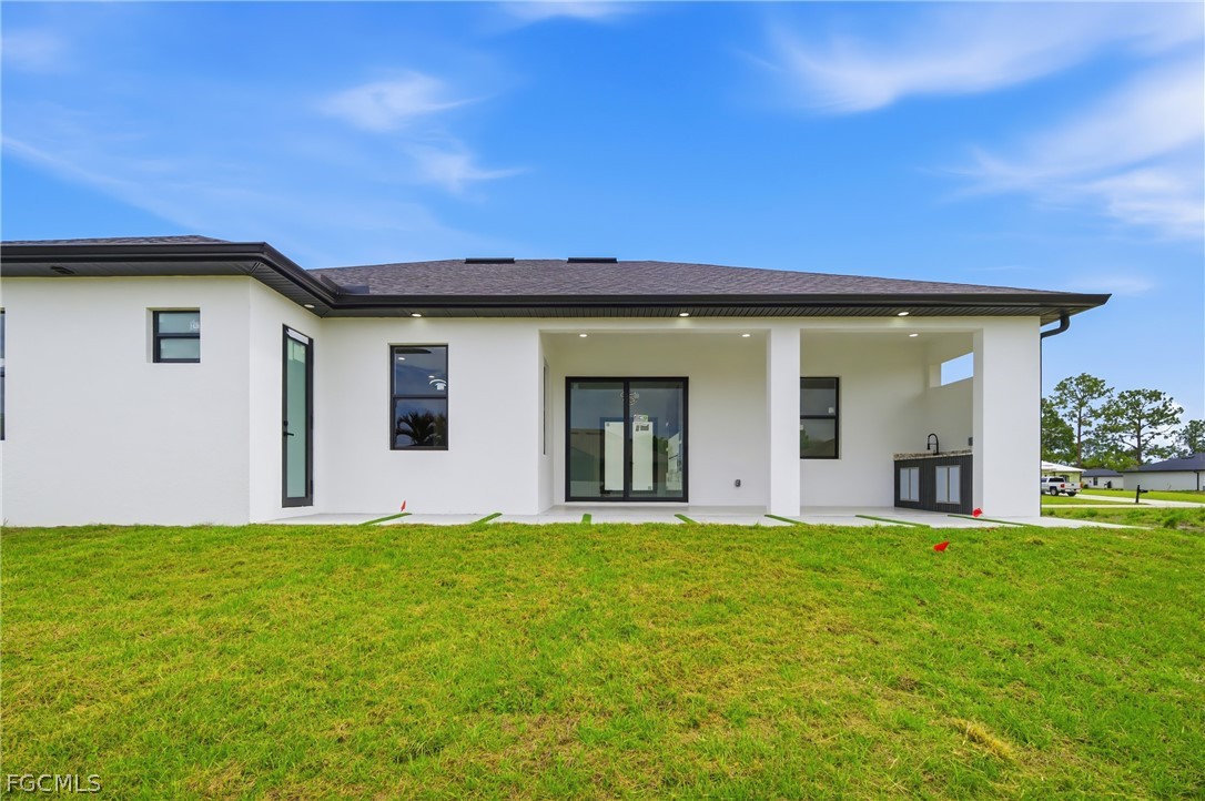 1013 Anson Avenue Lehigh Acres, FL 33971 - Photo 28 of 33 a view of a house with a yard
