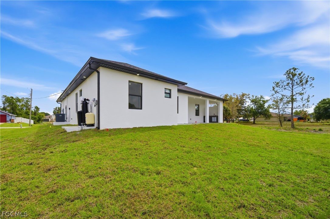 1013 Anson Avenue Lehigh Acres, FL 33971 - Photo 31 of 33 a front view of house with yard and green space