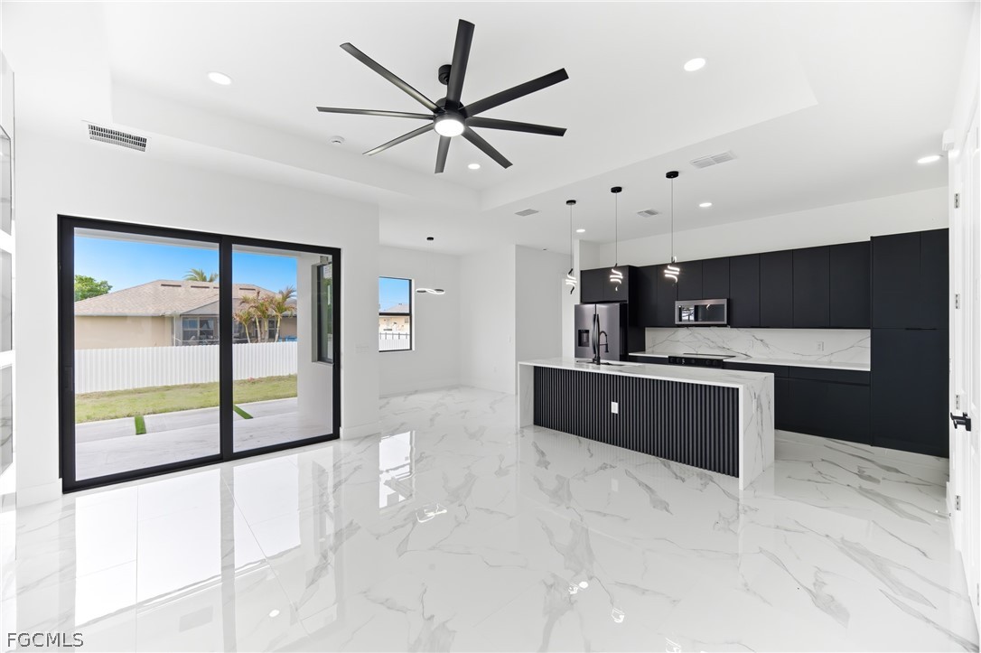 1013 Anson Avenue Lehigh Acres, FL 33971 - Photo 6 of 33 a large kitchen with stainless steel appliances a large counter top
