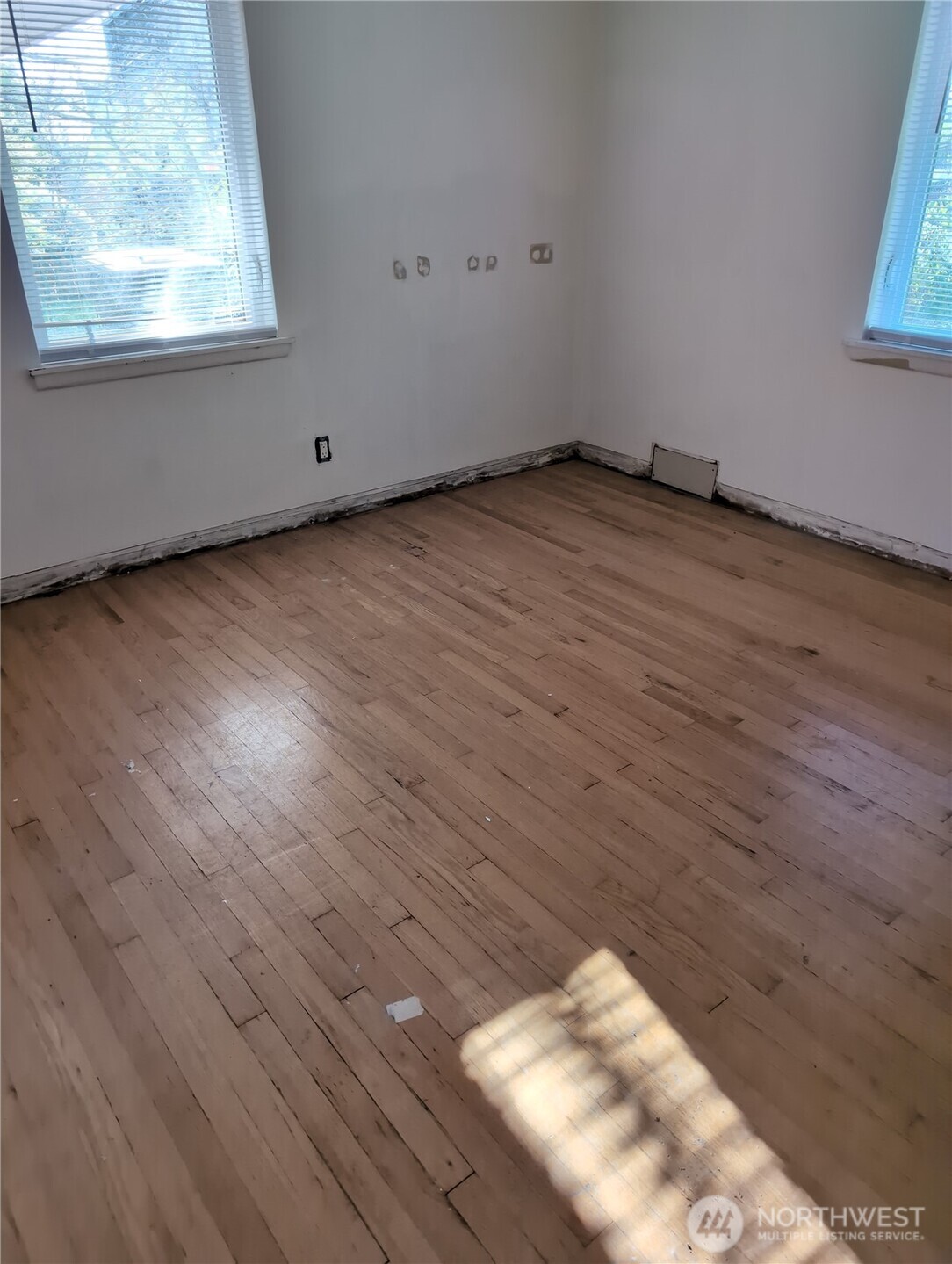 6925 52nd Avenue South Seattle, WA 98118 - Photo 6 of 9 a view of an empty room with wooden floor and a window