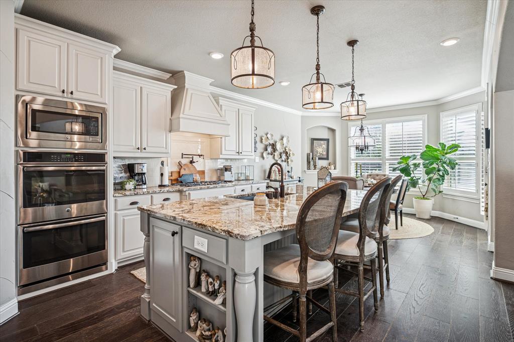 2880 Redfern Drive Trophy Club, TX 76262 - Photo 13 of 40 a kitchen with stainless steel appliances granite countertop a stove a kitchen island a stove and a refrigerator with wooden floor