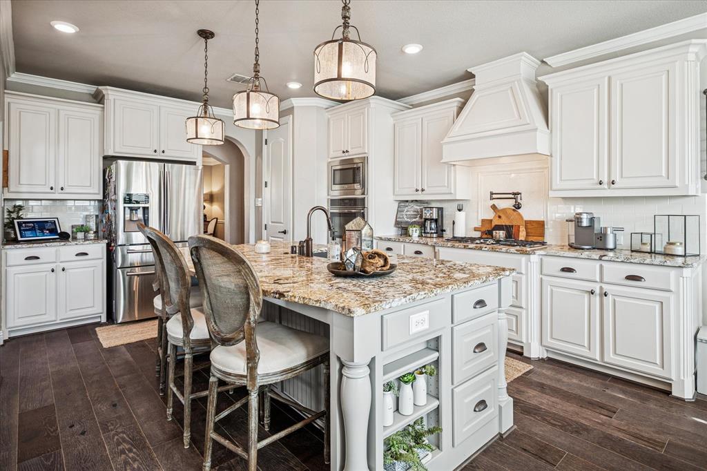 2880 Redfern Drive Trophy Club, TX 76262 - Photo 15 of 40 a kitchen with stainless steel appliances kitchen island granite countertop a table chairs and a refrigerator