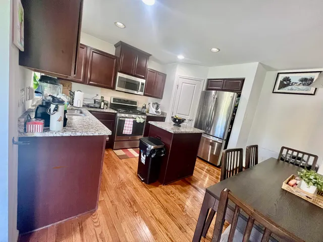 a view of a dining room and livingroom with furniture wooden floor a chandelier