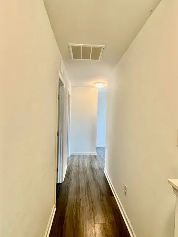 an empty room with wooden floor and a window