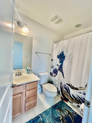 a white toilet sitting next to a bathroom sink and tub
