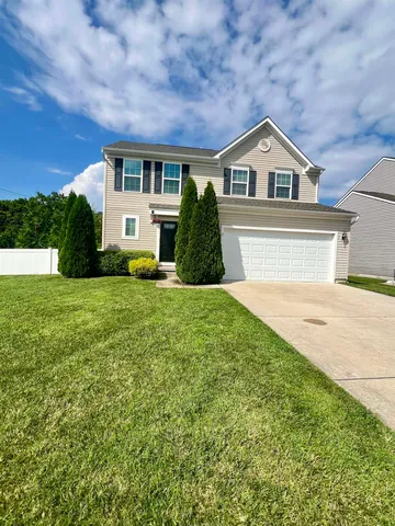 a view of house with yard and green space