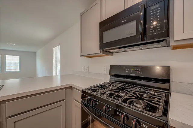 a kitchen with microwave stove and cabinets