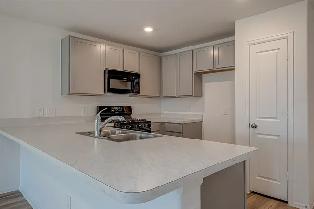 a kitchen with a sink a microwave and cabinets