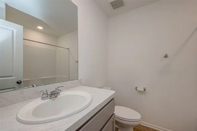 a bathroom with a sink a toilet and a mirror