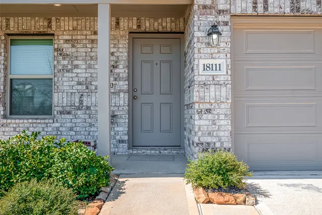 a view of front door of house with potted plants