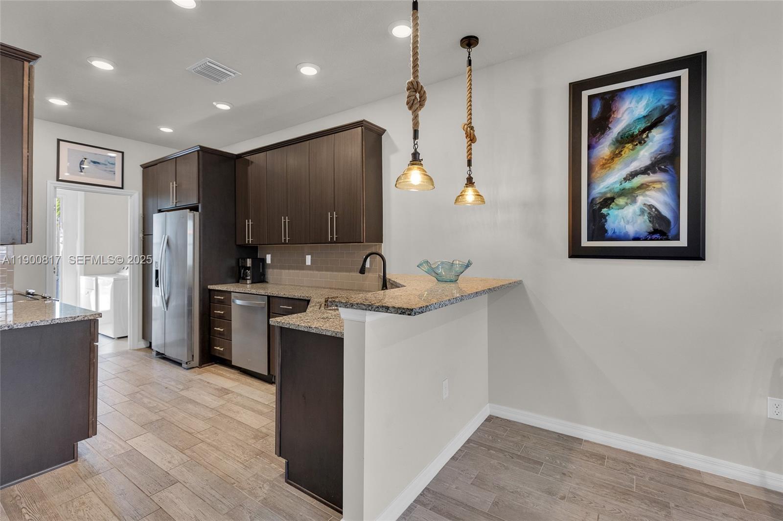 4810 Eucalyptus Drive, Unit 3 Hollywood, FL 33021 - Photo 11 of 32 a kitchen with a refrigerator sink and wooden cabinets