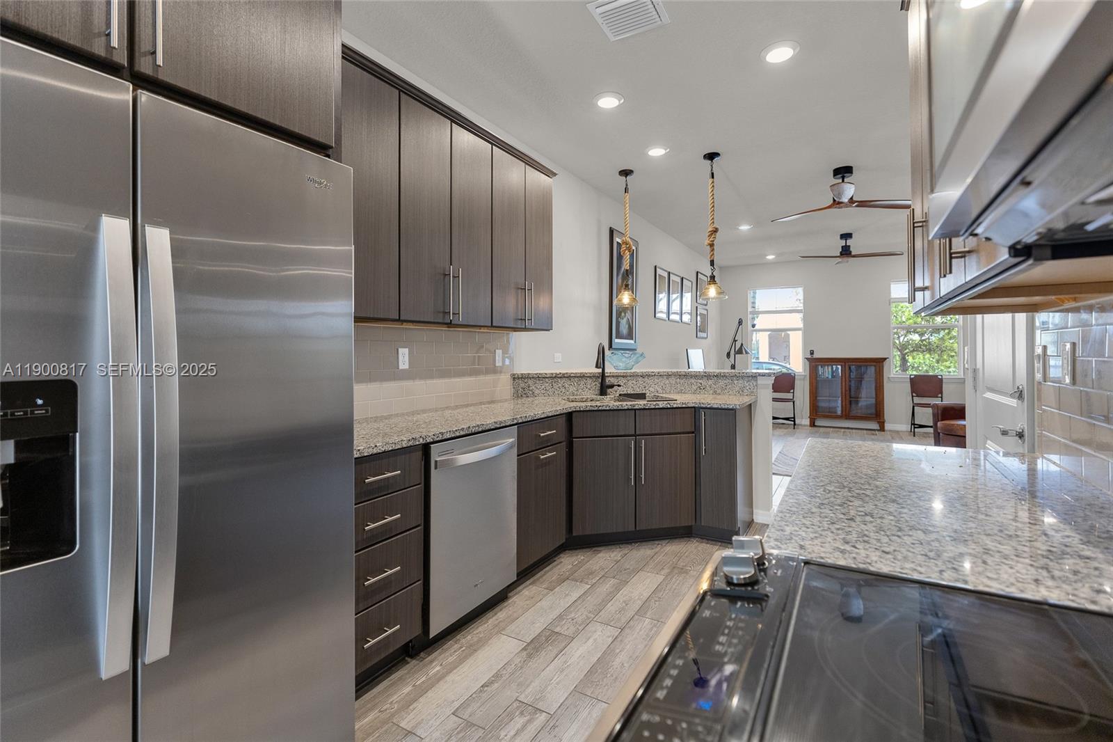 4810 Eucalyptus Drive, Unit 3 Hollywood, FL 33021 - Photo 9 of 32 a kitchen with kitchen island granite countertop a sink cabinets and stainless steel appliances
