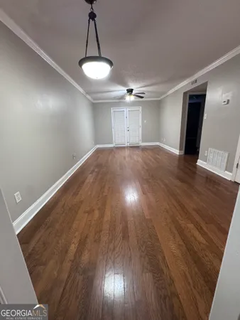 a view of empty room with wooden floor