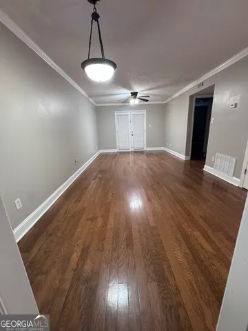 a view of empty room with wooden floor