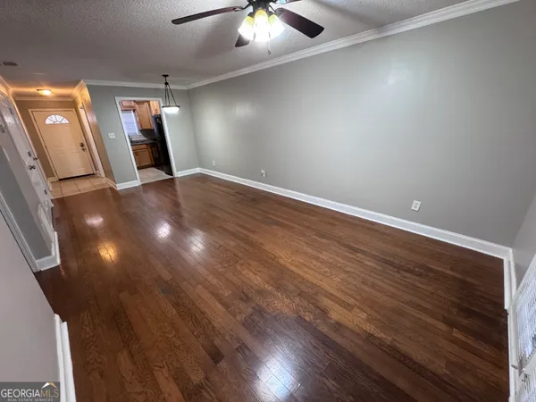 an empty room with wooden floor and mirror