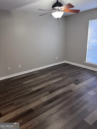 a view of a room with wooden floor and ceiling fan