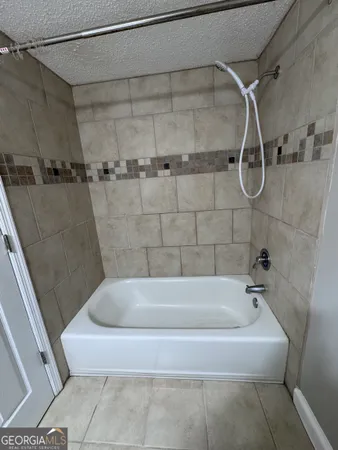 a white bath tub sitting next to a white sink and a shower