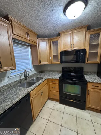 a kitchen with granite countertop a sink and cabinets