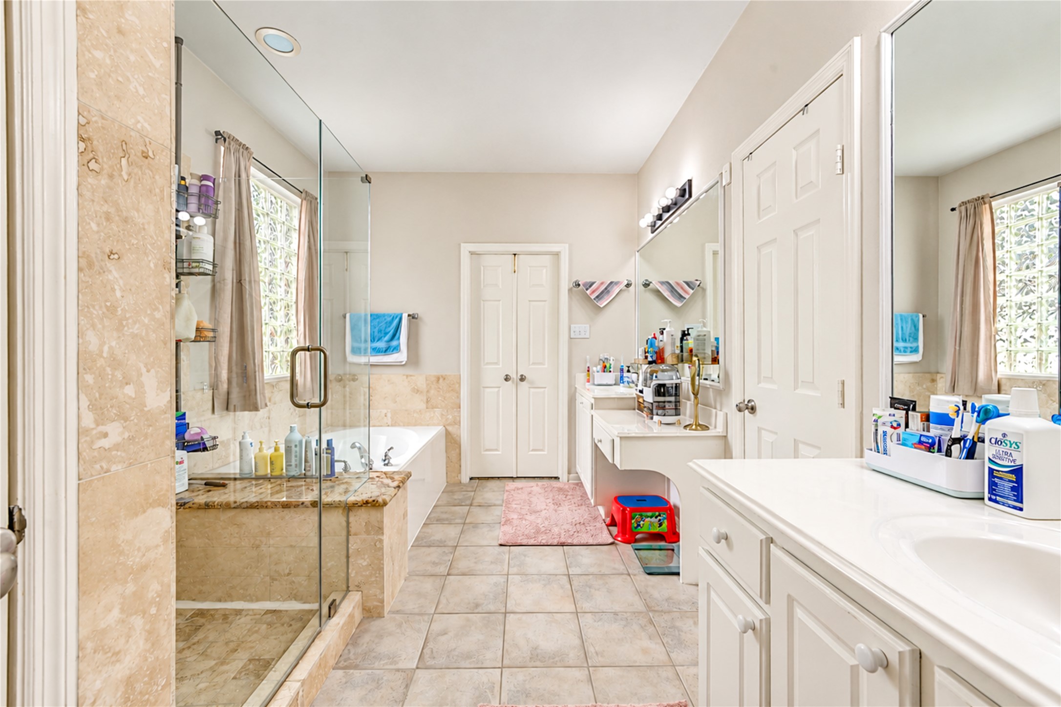 12806 Ridge Bank Lane Houston, TX 77041 - Photo 26 of 44 Spacious bathroom featuring a glass-enclosed shower, a luxurious soaking tub, and dual vanities with ample storage and counter space.