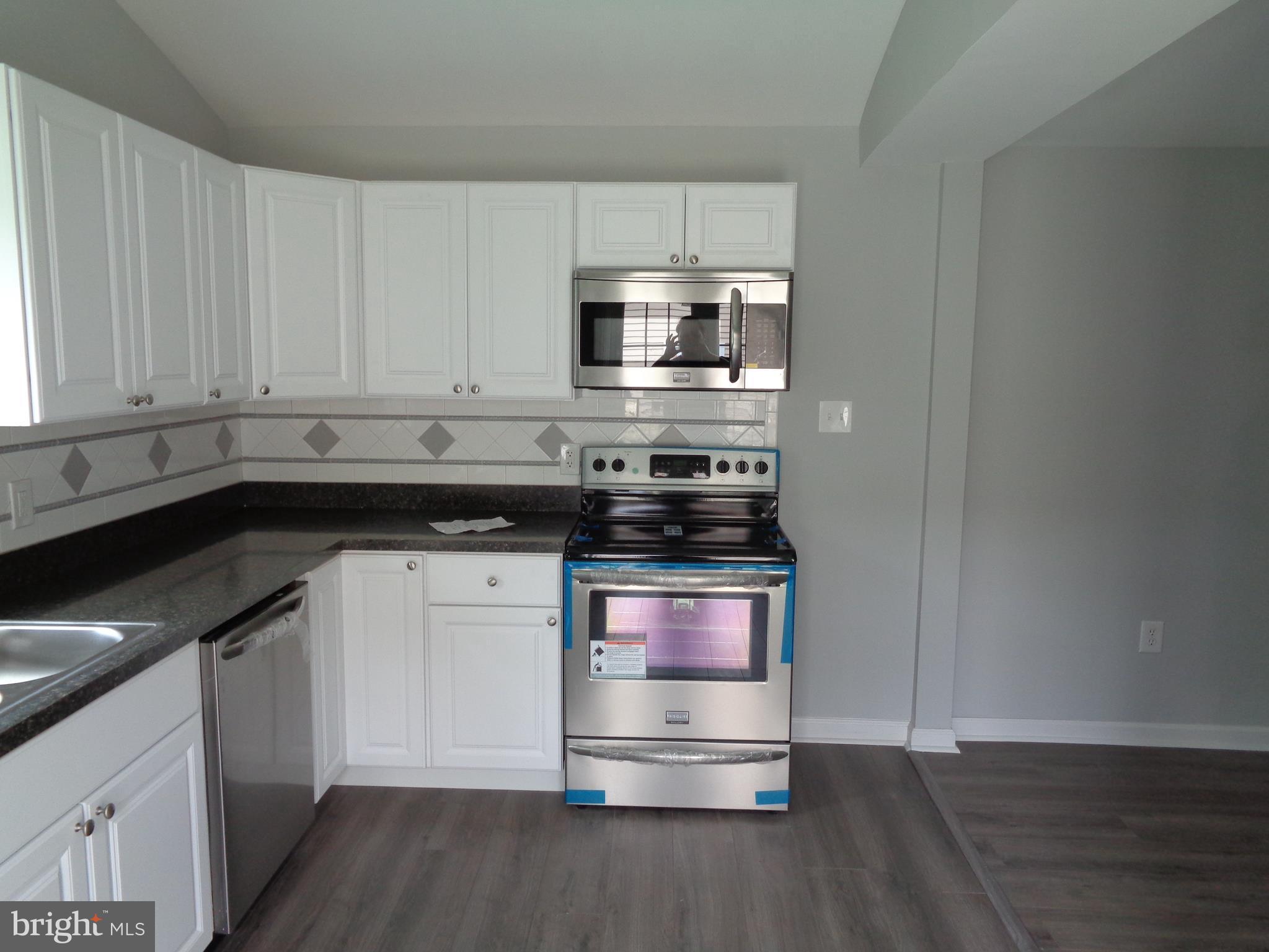 2709 Sparrows Point Road Baltimore, MD 21219 - Photo 3 of 17 a kitchen with stainless steel appliances granite countertop a stove and a microwave