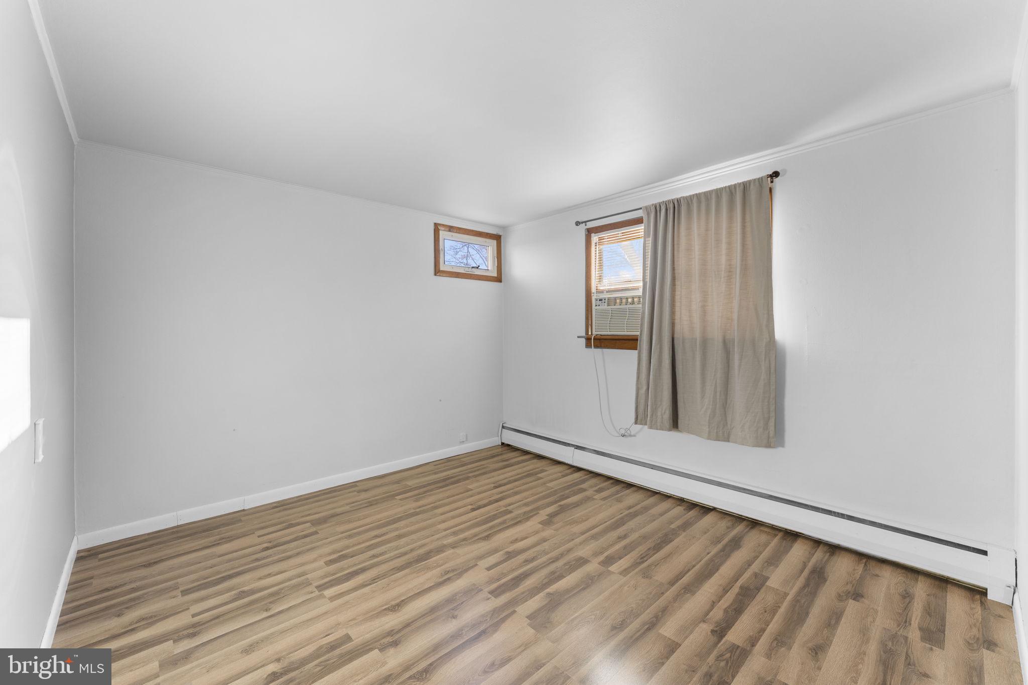 225 Pershing Avenue, Unit A Horsham, PA 19044 - Photo 14 of 19 an empty room with wooden floor and windows