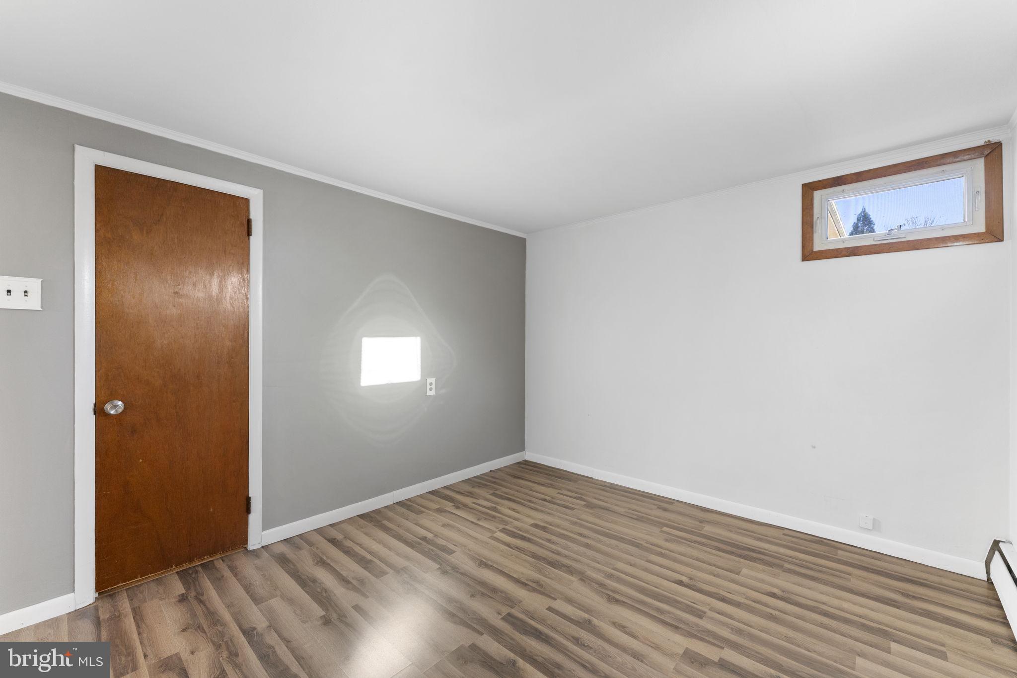 225 Pershing Avenue, Unit A Horsham, PA 19044 - Photo 17 of 19 a view of an empty room with wooden floor and a window